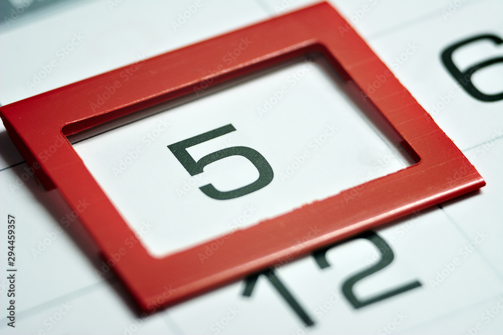 the fifth day of the month highlighted on the calendar with a red frame close-up macro, the mark on the calendar, the fifth date the fifth day of the month highlighted on the calendar with a red frame close-up macro, the mark on the calendar, the fifth date