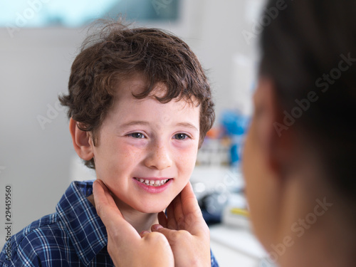 Female doctor examining a boy in a clinic photo