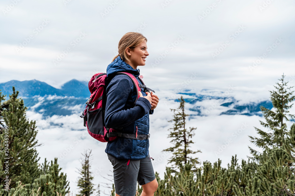 Smiling young woman on a hiking trip in the mountains, Herzogstand, Bavaria, Germany