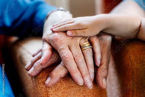 Elderly couple and baby's hand, generations together photo