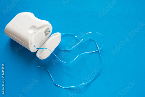 dental floss on a blue background, the concept of care for the oral cavity, preventing tooth decay