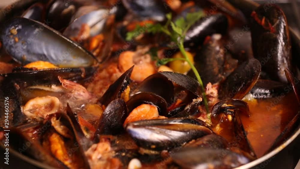 Cooked on the stove traditional italian mediterranean fish soup with shrimp,mussels tomato, squid,clams.Seafood.Close up Cooked on the stove traditional italian mediterranean fish soup with shrimp,mussels tomato, squid,clams.Seafood.Close up