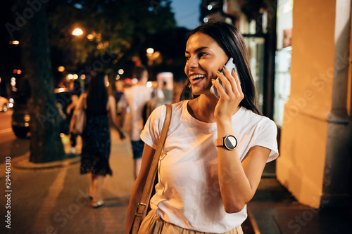 Young woman using smartphone in the city at night photo