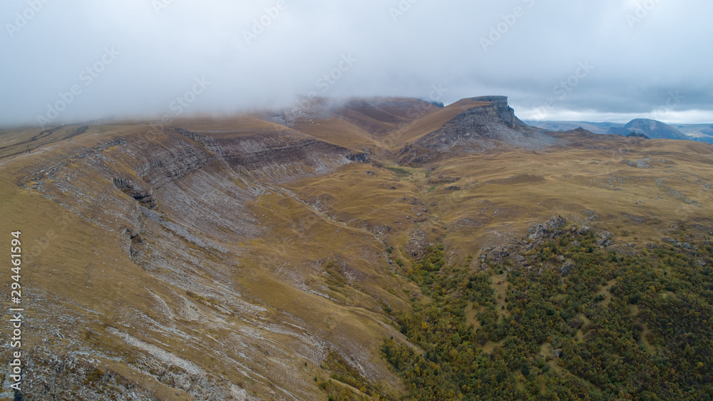 Wild mountainous place in autumn with yellow, red and green trees. Wild mountainous place in autumn with yellow, red and green trees.