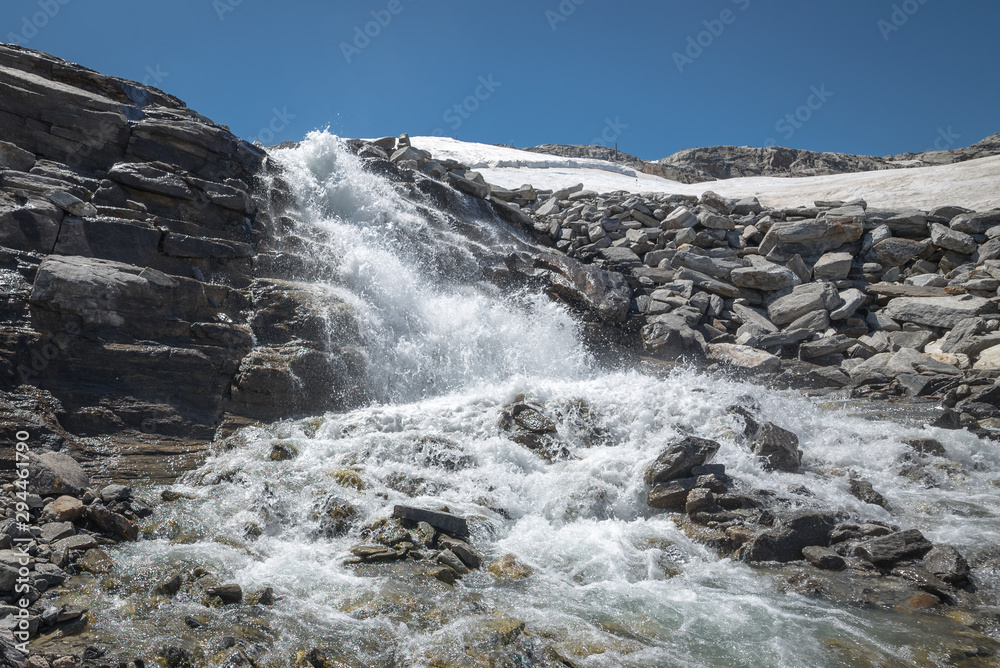 Water streaming down from rocks on a glacier in the Alps