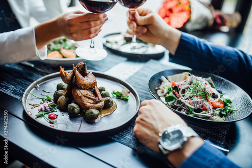 Restaurant table set main dish steak fish cuisine fine dinning white wine glass cooler candle light wooden table atmosphere.