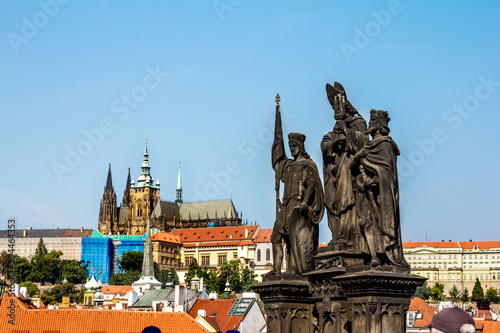 Sculpture of Saints Norbert, Sigismund and Wenceslas on the Charles bridge on the background of Prague castle.