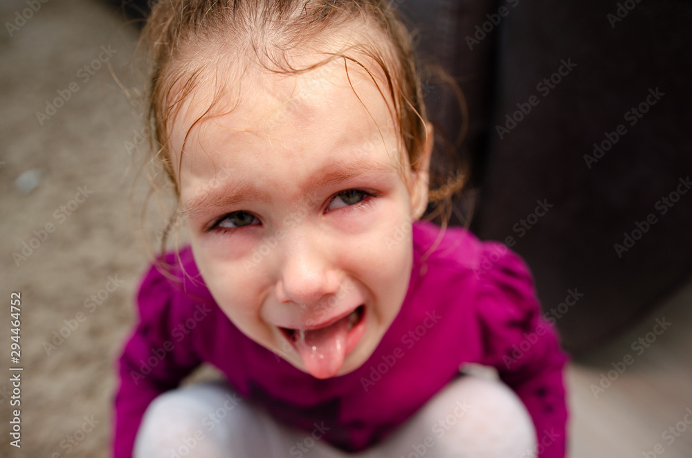 Little girl sitting on the floor, she is upset and crying. The child is crying sitting on the floor in the room. Little girl sitting on the floor, she is upset and crying. The child is crying sitting on the floor in the room.