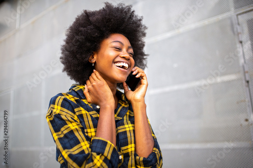 young black woman walking and talking with cellphone