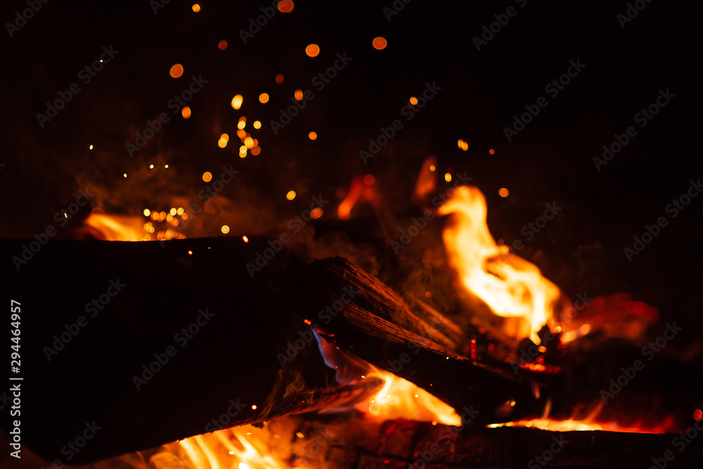 Beautiful abstract background on the theme of fire, light and life. Burning red hot sparks fly from large fire in the night sky. Burning embers glowing flying over black background. Beautiful abstract background on the theme of fire, light and life. Burning red hot sparks fly from large fire in the night sky. Burning embers glowing flying over black background.