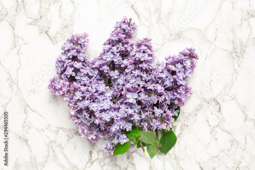 Purple lilac flowers on marble background  simple composition for holiday