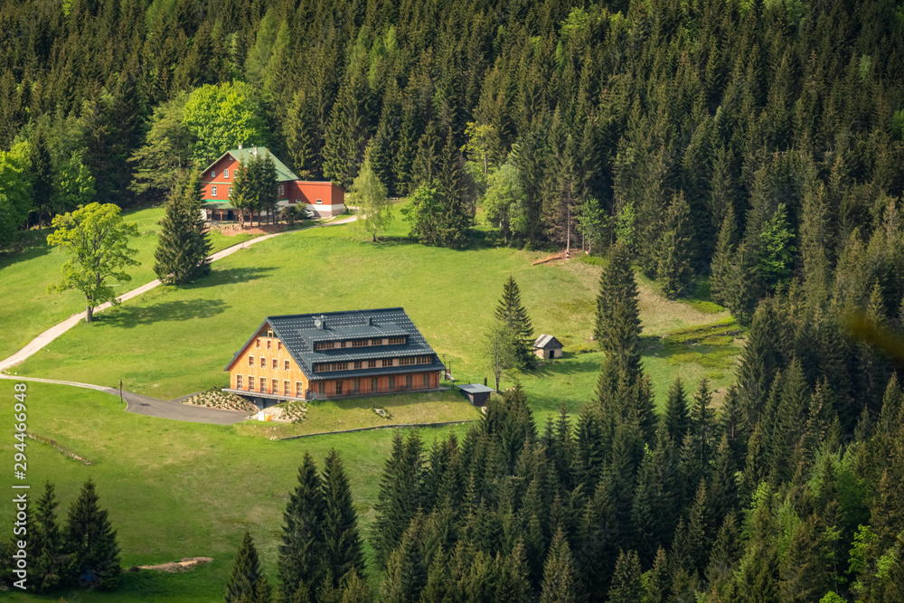 Beautiful landscape of Krkonose mountains with few romantic cottages and trees around
