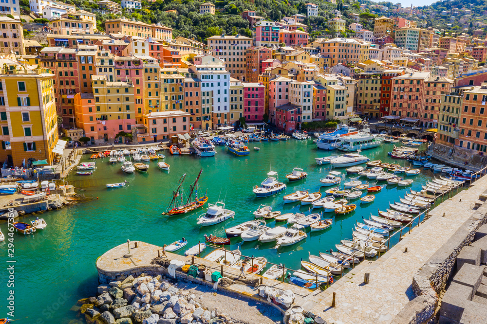 Aerial view of Camogli. Colorful buildings near the ligurian sea beach. View from above on boats and yachts moored in marina with green blue water.