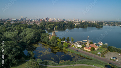 Dutch mill in early morning light. View on the skyline of Rotterdam as seen from the Kralingse Bos