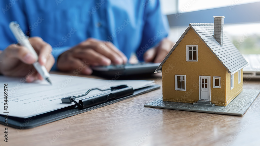 Fototapeta premium House model with agent and customer discussing for contract to buy, get insurance or loan real estate or property background