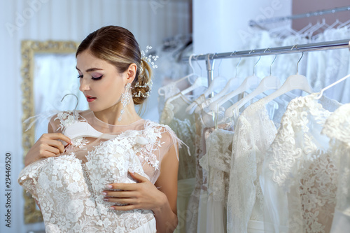 Young woman measures wedding dresses.