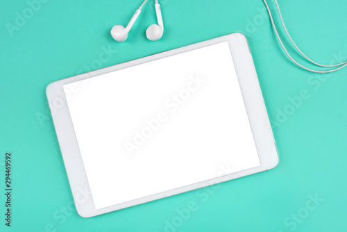 White digital tablet on mint background.