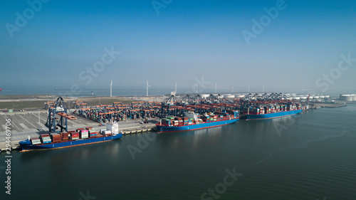  Aerial view of container terminal in the harbor MAASVLAKTE, Netherlands. A large containership from Cosco is unloading