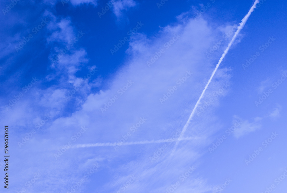 Blue sky with white clouds and lines from aircraft Blue sky with white clouds and lines from aircraft