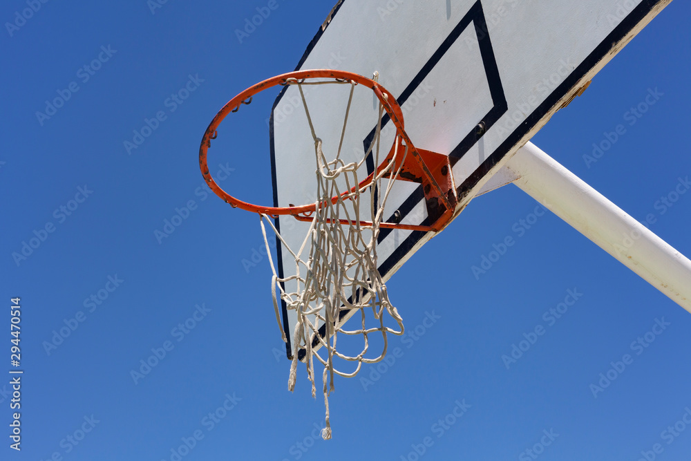 Outdoor basketball hoop against a blue sky - street basketball