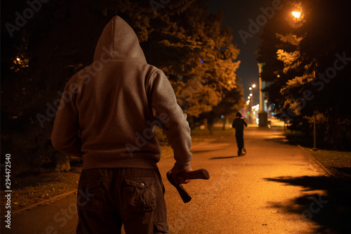 Billede på lærred A man with an ax is about to attack a child at night on the street