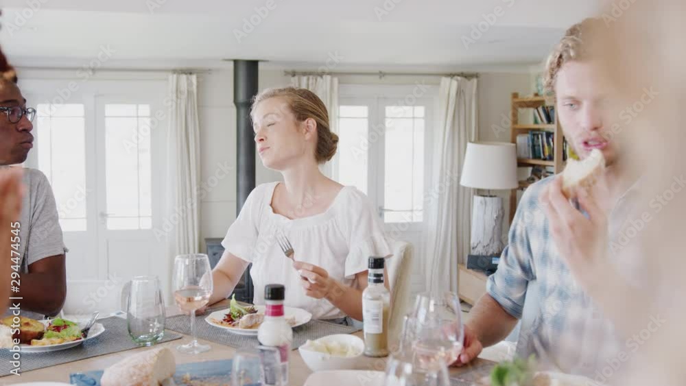 Group Of Young Friends Sitting Around Table At Home Enjoying Meal Together Group Of Young Friends Sitting Around Table At Home Enjoying Meal Together