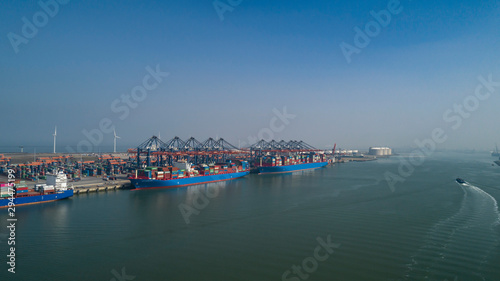  Aerial view of container terminal in the harbor MAASVLAKTE, Netherlands. A large containership from Cosco is unloading
