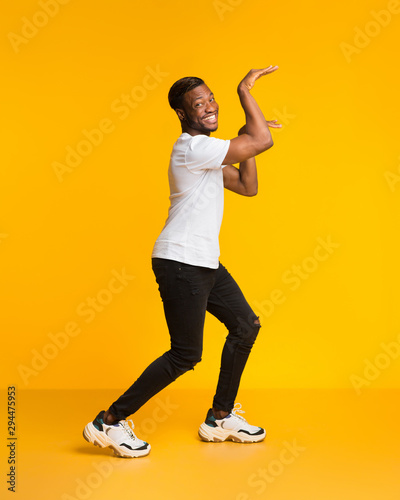 Funny Man Dancing In Egypt Style Fooling Over Yellow Background © Prostock-studio