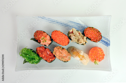 Japanese sushi of seaweed roll with Ikura, Ebiko, Hotate, Wakame, Kurage on ceramic plate photo