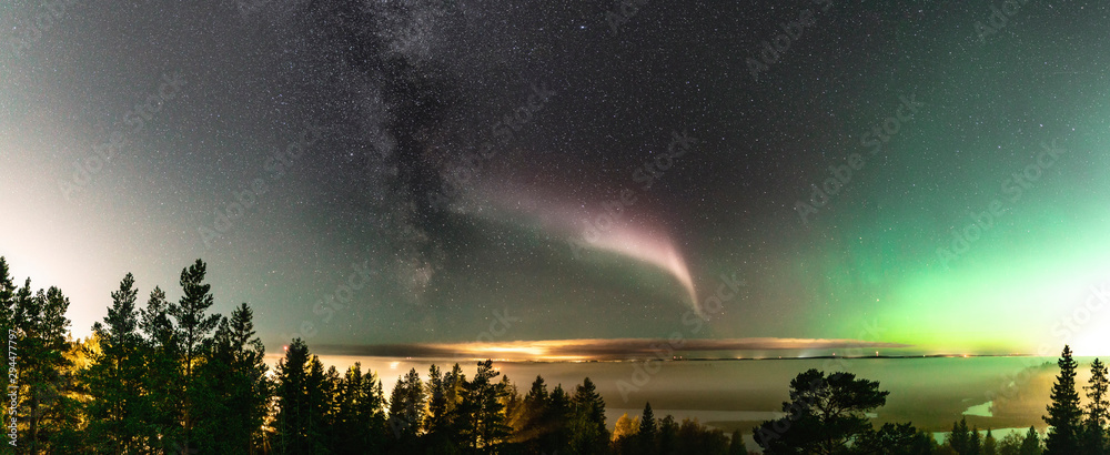 Panoramic view of Northern Lights and atmospheric phenomenon 'STEVE' meets Milky Way. Steve appears as a purple and green light ribbon in the sky at an altitude of 450 km. Northern Sweden Scandinavia