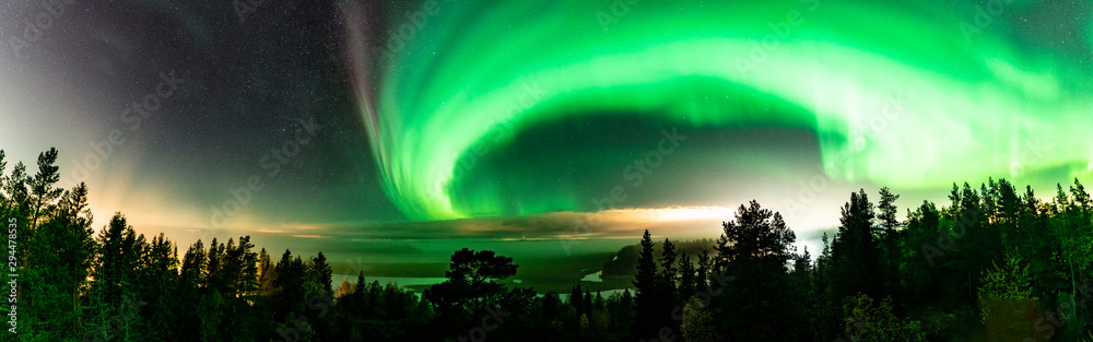 Panoramic view of Strong Northern Lights and atmospheric phenomenon 'STEVE' meets Milky Way. Steve appears as a purple and green light ribbon at height of 450 km. Northern Sweden Scandinavia