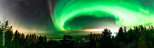 Panoramic view of Strong Northern Lights and atmospheric phenomenon 'STEVE' meets Milky Way. Steve appears as a purple and green light ribbon at height of 450 km. Northern Sweden Scandinavia
