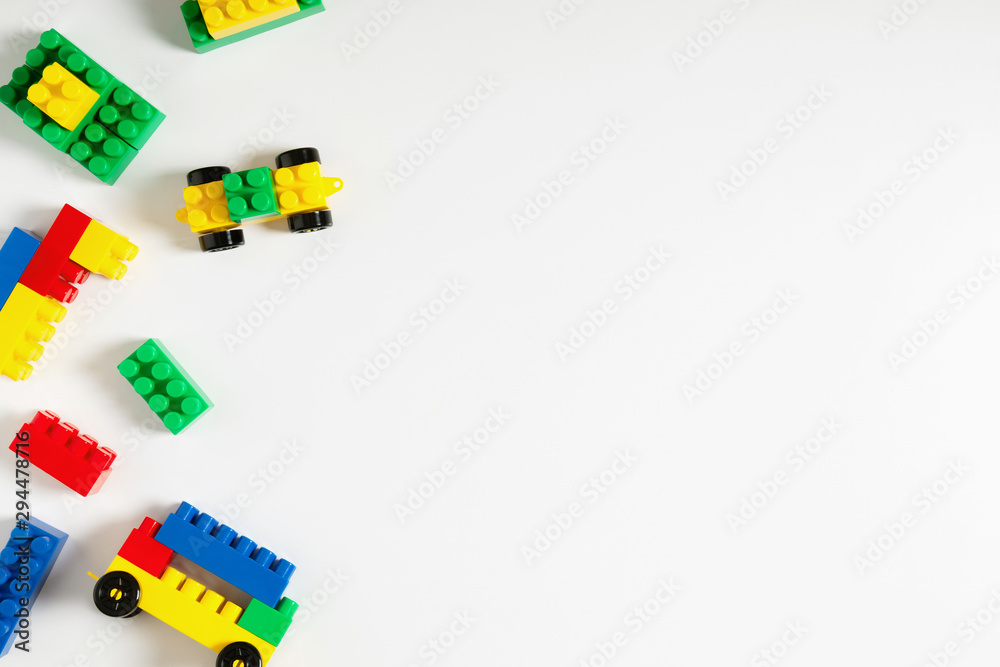 Kids toys and colorful blocks on white background. Flat lay, top view, copy space