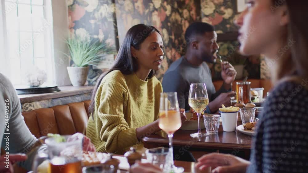 Group Of People Eating In Restaurant Of Busy Traditional English Pub