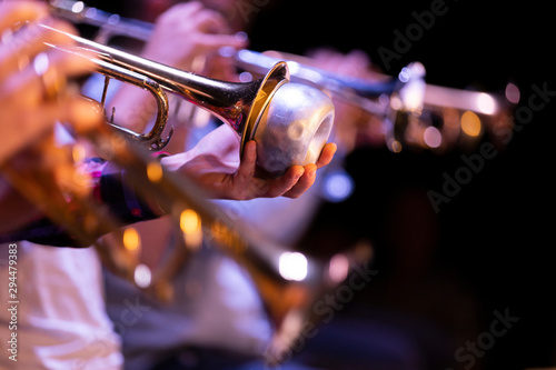 A musician of a trumpet section in a big band playing with a bubble, wah-wah mute