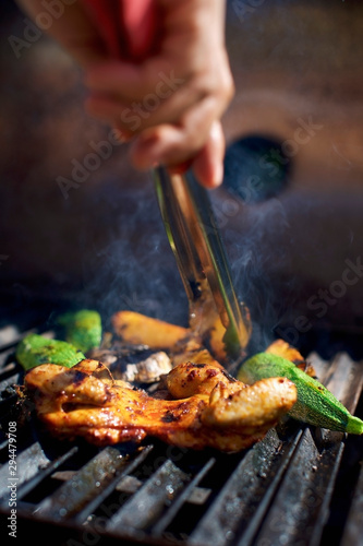 Close up chef grilling meat and vegetables on grill
