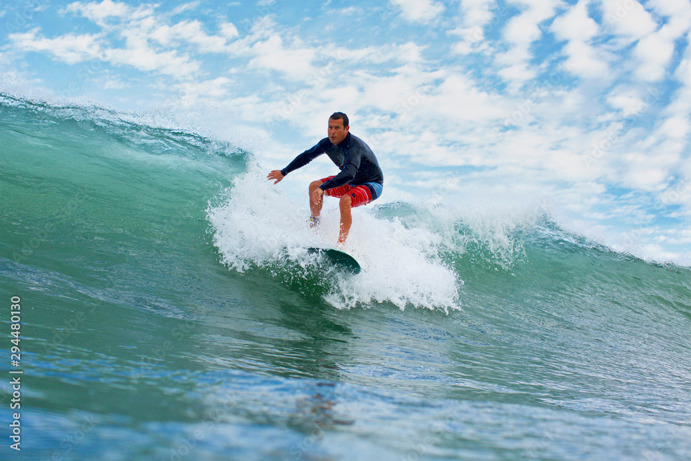 Male surfer riding ocean wave Male surfer riding ocean wave