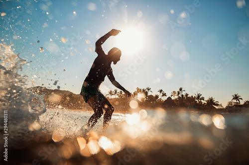 Silhouette of man surfing on sea wave