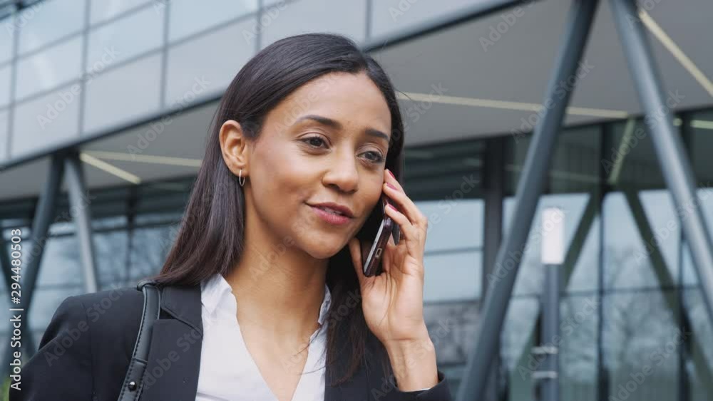 Businesswoman Commuting To Work Talking On Mobile Phone Outside Modern Office Building Businesswoman Commuting To Work Talking On Mobile Phone Outside Modern Office Building