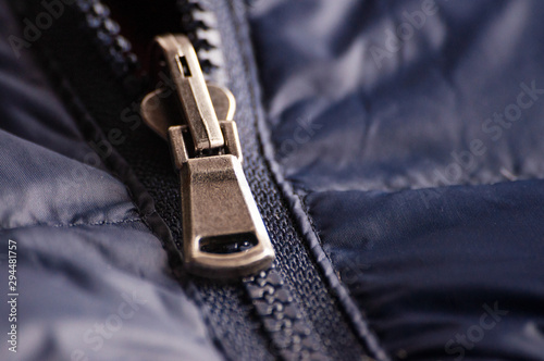 Zipper slider on. Buttoning and unfastening clothes. Close-up, selective focus.
