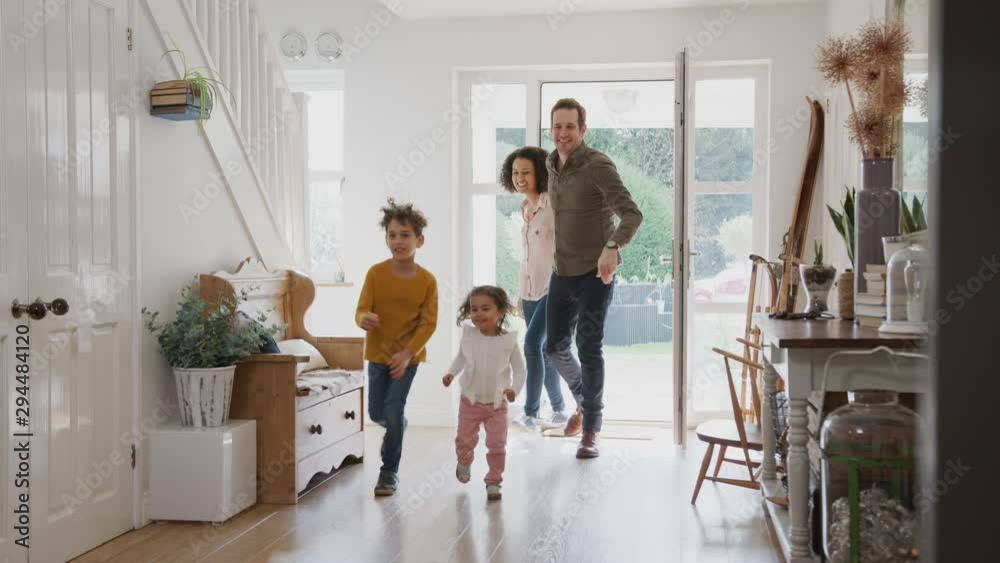 Family Returning Home After Trip Out With Excited Children Running Ahead