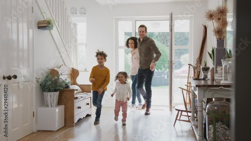 Family Returning Home After Trip Out With Excited Children Running Ahead