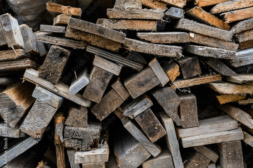 Folded old wooden brown and gray planks in a sawmill. Piled alder boards as texture. Folded old wooden brown and gray planks in a sawmill. Piled alder boards as texture.