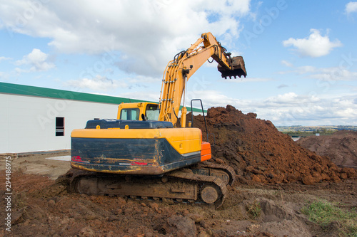 Work of special equipment at a construction site. Crawler excavator performs earthwork.