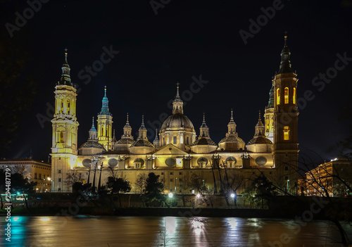Cathedral Basilica of Our Lady of The Pillar at night with reflections on Ebro River in Zaragoza, Spain