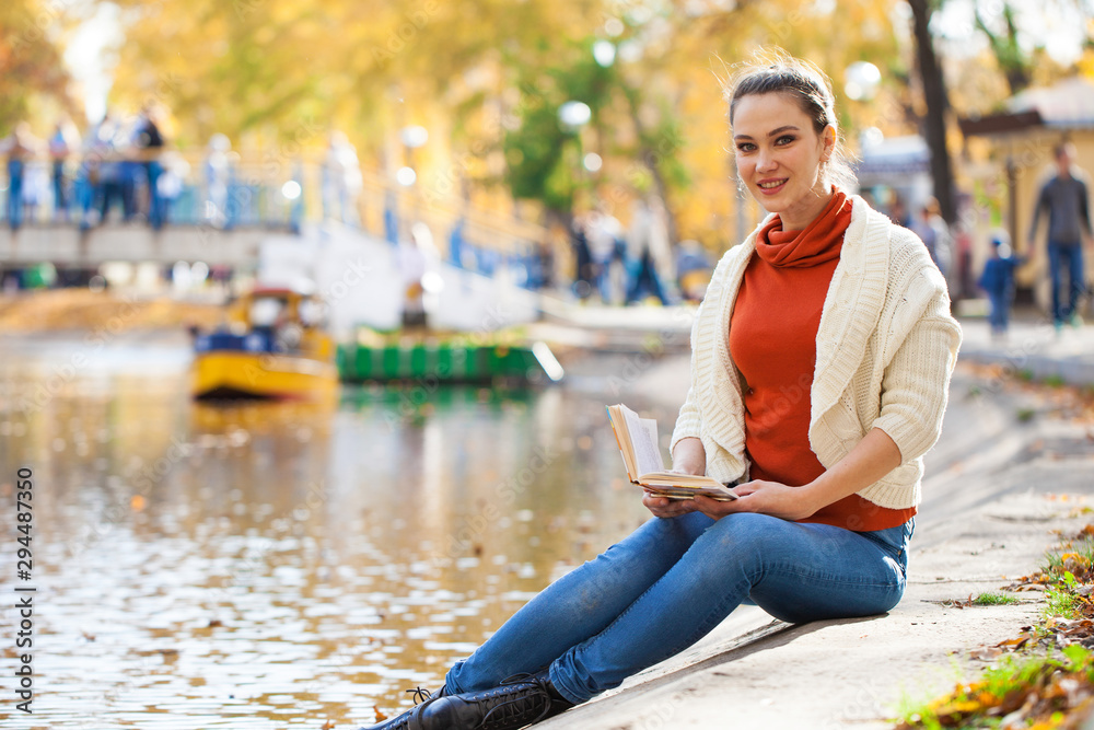 Young beautiful woman reading a book in autumn park Young beautiful woman reading a book in autumn park