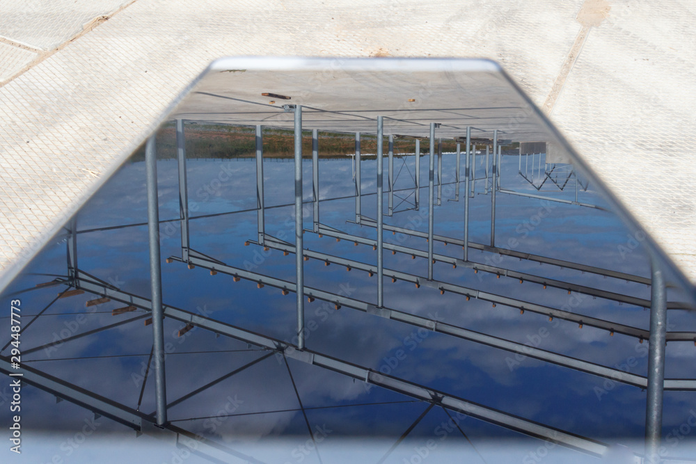 Fototapeta premium Industrial background. Reflection of a building construction from a metal frame in the phone.