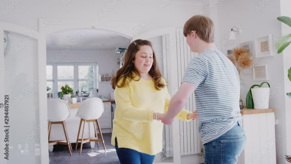 Young Downs Syndrome Couple Having Fun Dancing At Home Together Young Downs Syndrome Couple Having Fun Dancing At Home Together