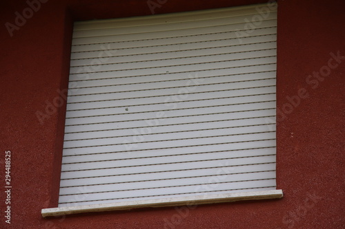 White protective shutters punctured by hail photo