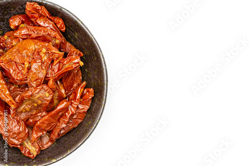 Lot of slices of dry red cherry tomato copyspace on grey ceramic plate flatlay isolated on white background